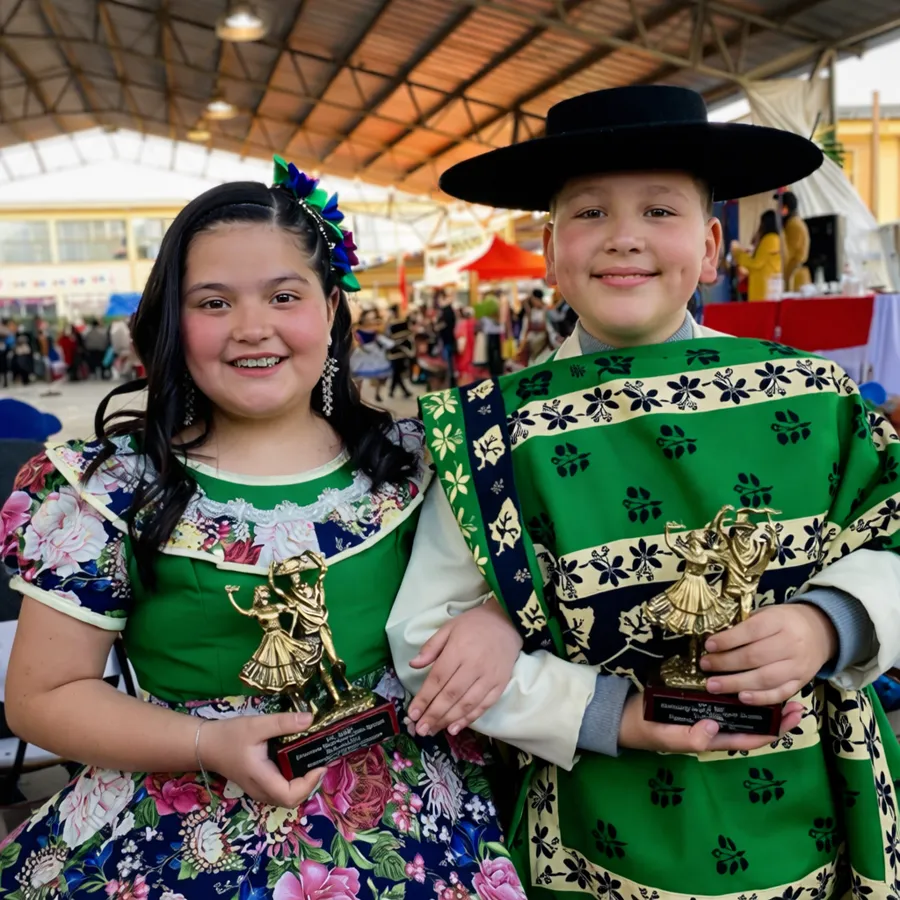 Ninos en traje de cueca con sus trofeos de premiacion